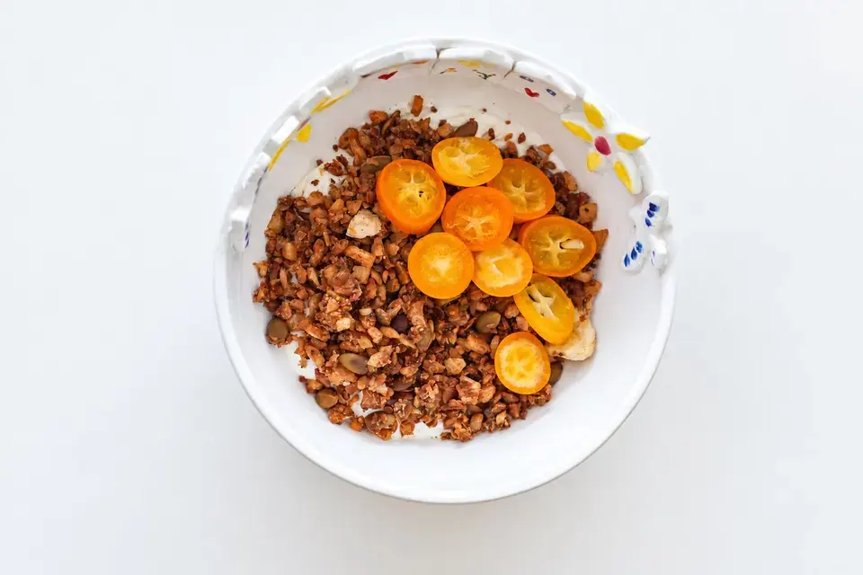 Dried fruit granola and yogurt topped with sliced kumquats