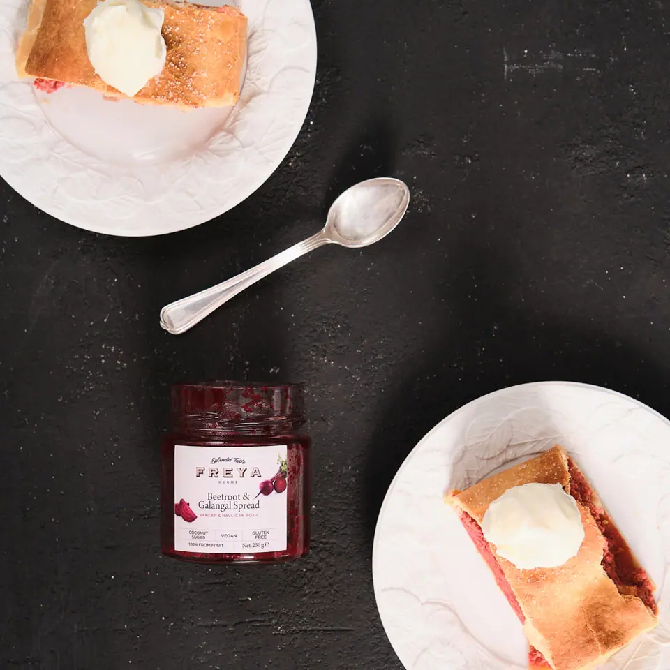 Beet and galangal ricotta strudel slices on two white plates
