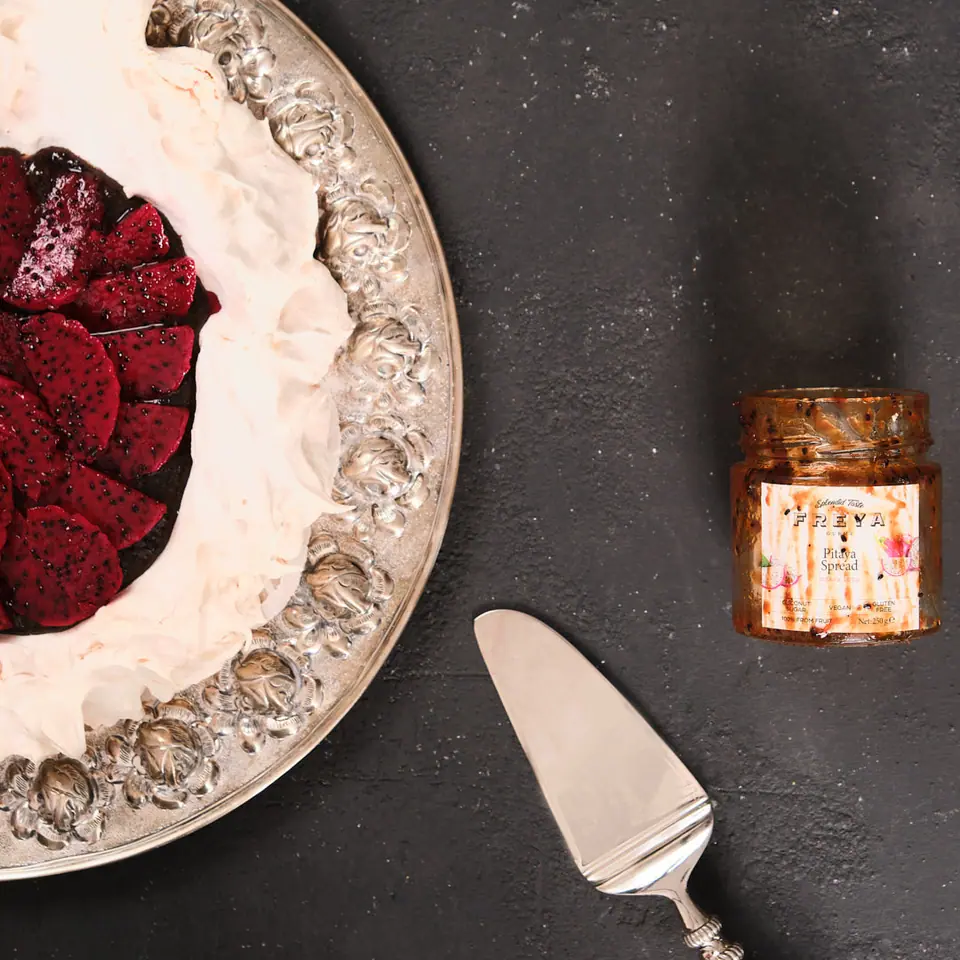 Dragon fruit pavlova with white cream and bright pink fruit topping