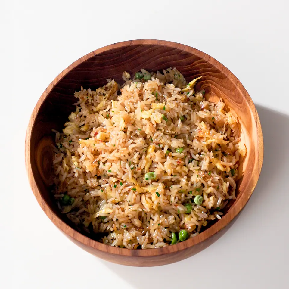 Ginger-spiced pear fried rice with vegetables in a wooden bowl