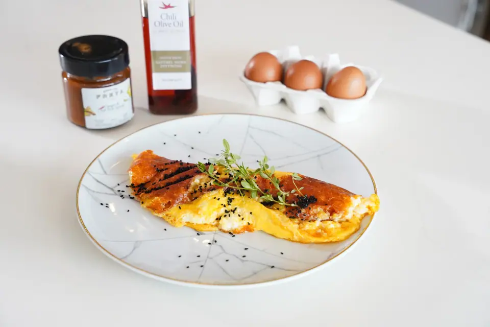 Golden mozzarella omelet with ginger-spiced pear, garnished with fresh herbs