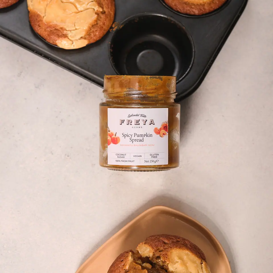 Spiced pumpkin muffins in a dark muffin pan and serving bowl